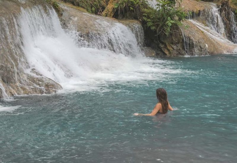 Jasmin steht im Wasser des Cambugahay Wasserfalls in Siquijor auf den Philippinen