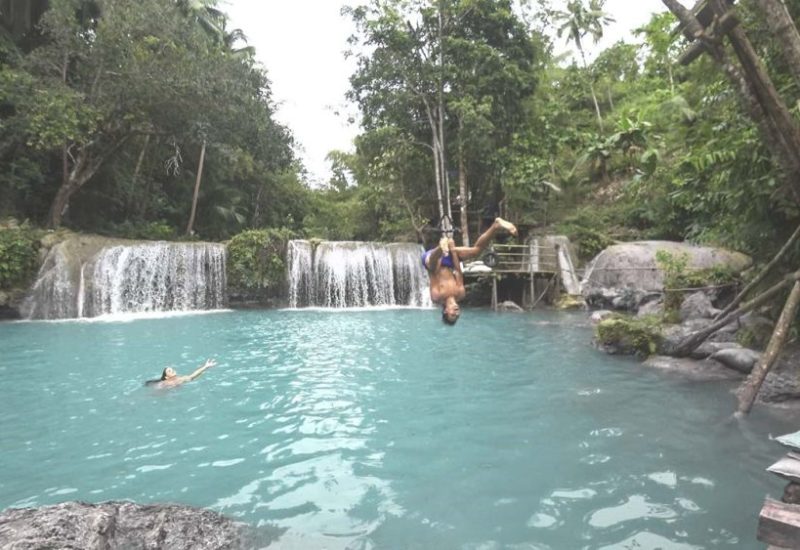 Valentin springt an einer Liane in den Cambugahay Wasserfall