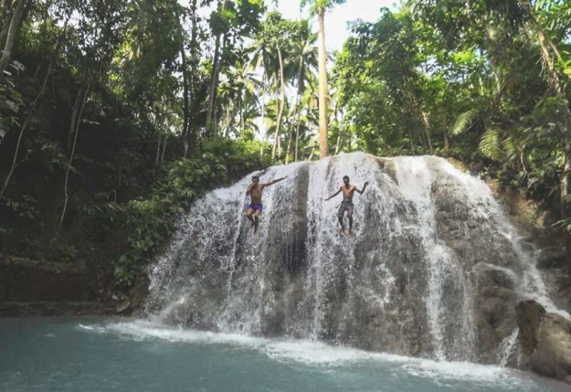 Valentin springt mit einem Einheimischen vom Lugnason Wasserfall auf Siquijor in den Philippinen